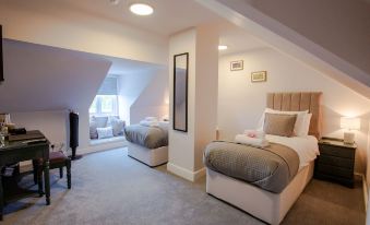 a cozy bedroom with two beds , one of which is made up and has a mirror on the wall at Woodfalls Inn