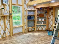 Elevated eclectic yurt with wrap-around porch, hot tub, and mountain view!