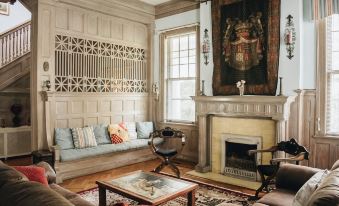 a cozy living room with wooden furniture , including a couch , chairs , and a coffee table at 1912 Bed and Breakfast