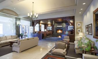 a large hotel lobby with a fireplace , multiple couches , chairs , and a television mounted on the wall at Parador de Las Canadas del Teide