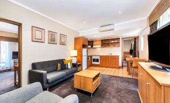 a living room with a gray couch , wooden coffee table , and kitchen in the background at Comfort Inn & Suites Sombrero