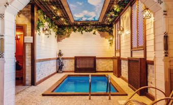 a small indoor swimming pool surrounded by wooden walls , with a lounge chair placed in front of it at Voyage Hotel
