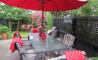 a patio set with a table , chairs , and an umbrella is surrounded by a fence at The Loft Bed and Breakfast