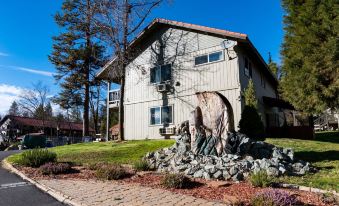 a large house with a statue in front of it and a parking lot below at Yosemite Westgate Lodge