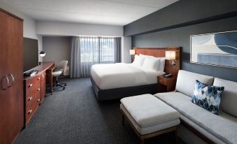 a large hotel room with a king - sized bed , a couch , and a desk with a laptop at Courtyard Shelton