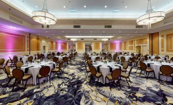 a large , well - decorated banquet hall with multiple tables and chairs set up for a formal event at DoubleTree Boston North Shore Danvers