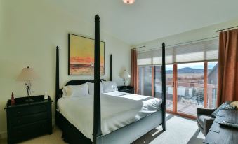 a bedroom with a large bed , a painting on the wall , and a sliding glass door leading to a balcony at Newpark Resort