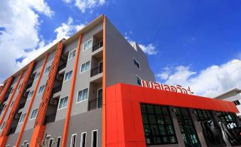 a modern building with an orange and gray facade , surrounded by clear blue skies and clouds at Belleville Hotel