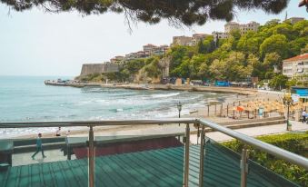a beautiful beach scene with a wooden deck overlooking the ocean , where people are enjoying their time at Riva