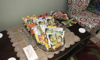a dining table with a variety of snacks , including chips , crackers , and nuts , placed on a tray at Cold Spring Hotel