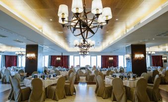 a large banquet hall with multiple dining tables and chairs set up for a formal event at Parador de Salamanca