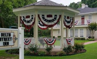 a white gazebo decorated with american flags and banners , creating a festive and patriotic atmosphere at Delta Street Inn