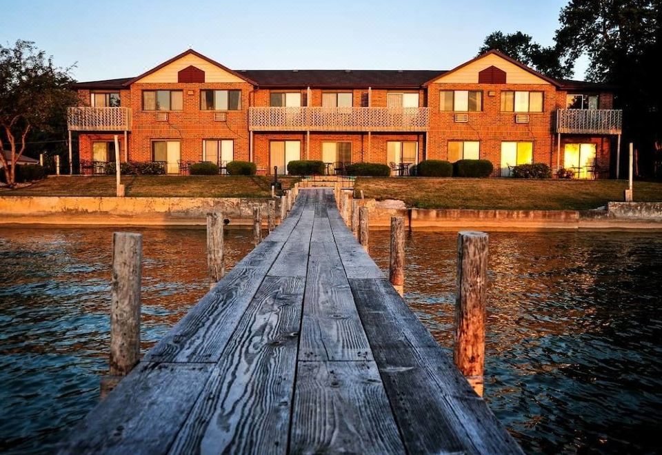 a wooden dock extending into a body of water , with several boats docked at the pier at Lakeside Inn