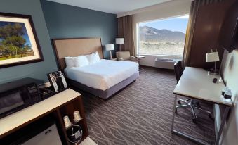 a hotel room with a king - sized bed , a desk , and a window overlooking the mountains at Cahuilla Casino Hotel