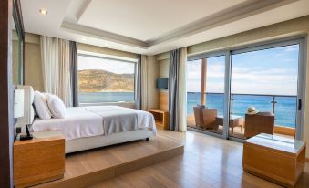 a luxurious bedroom with a large bed , hardwood floors , and a balcony overlooking the ocean at Konstantinos Palace
