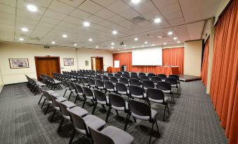 an empty conference room with rows of chairs arranged in a semicircle , ready for a meeting at Best Western Park Hotel