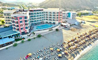 aerial view of a hotel on the beach with umbrellas and people walking around it at Konstantinos Palace