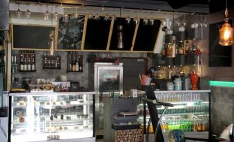 a coffee shop with a bar and shelves filled with various beverages , including coffee , tea , and other items at Jalandhar Shangrila Hotel