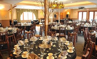 a well - decorated dining room with multiple tables set for a formal event , each table having its own unique arrangement of place settings at Woodstock Inn, Station and Brewery