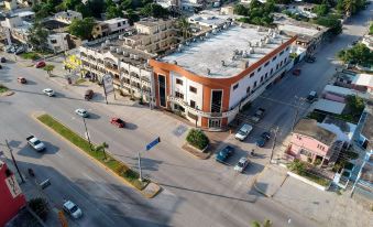 a large building with a parking lot in front of it and cars driving on the street at Hotel Mediterraneo