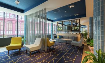 a modern living room with various seating options , including couches , chairs , and a coffee table at Hampton by Hilton Antwerp Central Station