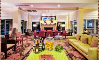 a large , well - decorated living room with various furniture and decorations , including a couch , chairs , and a dining table at Hilton Garden Inn Chesterton