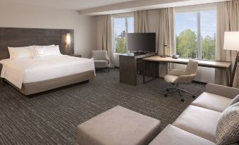 a hotel room with a king - sized bed , a desk , a chair , and a flat - screen tv at Residence Inn Halifax Dartmouth