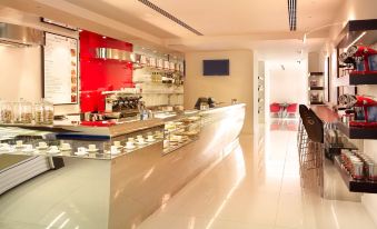 a modern coffee shop with a red and white color scheme , featuring a coffee bar and seating area at Park Plaza Westminster Bridge London