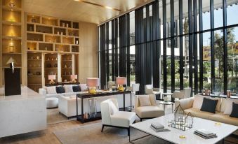 a modern lounge area with white couches , chairs , and a large window overlooking the city at Hotel Sa Barrera - Adults Only