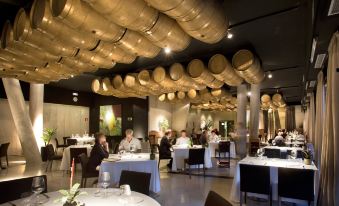 a large , well - lit restaurant with multiple dining tables and chairs , filled with people enjoying their meals at Hotel Viura