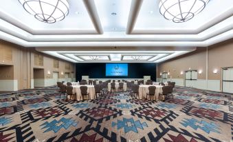 a large , empty conference room with round tables and chairs set up for a meeting or event at The Wigwam