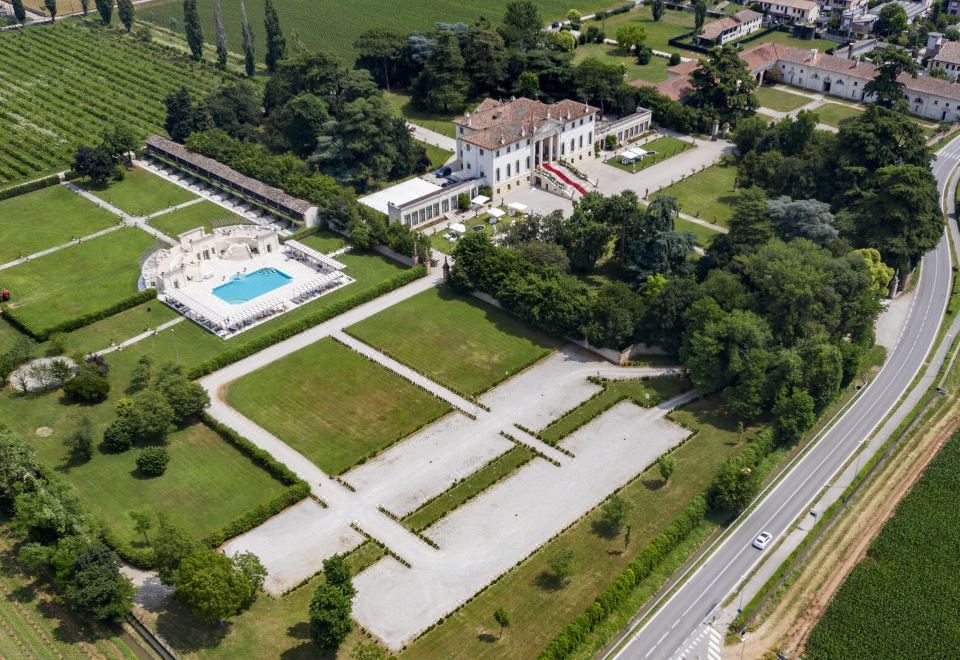 a bird 's eye view of a large white building surrounded by a grassy field and a parking lot at Hotel Relais Villa Corner Della Regina