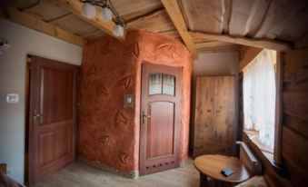 a wooden door with intricate carvings is the focal point of a room with exposed wood beams and walls at Troll