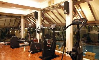 a well - equipped gym with various exercise equipment , such as treadmills , stationary bikes , and weight machines at Resor Tuban Tropis