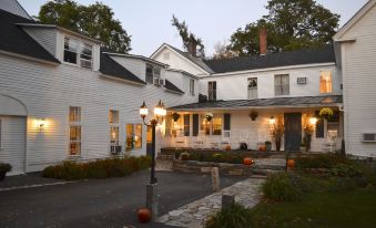 a white house with a driveway and stone walkway , surrounded by trees and lit up at night at Dowds Country Inn