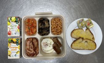 a tray filled with a variety of food items , including eggs , beans , and other dishes at Raintree Motel