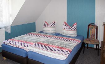 a bed with a blue and white striped blanket is shown in a room with blue walls at Mary