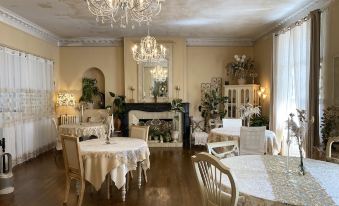 a well - decorated dining room with white tablecloths , chairs , and a fireplace , creating a warm and inviting atmosphere at The Corner Properties