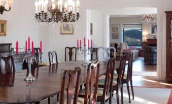 a dining room with a large wooden dining table , surrounded by chairs and a chandelier at Quinta Da Marka