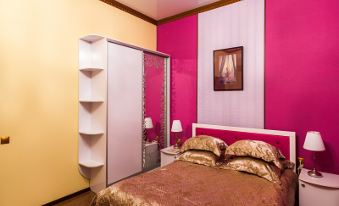 a bedroom with a pink and yellow color scheme , featuring a bed , nightstands , and a closet at Diana Hotel