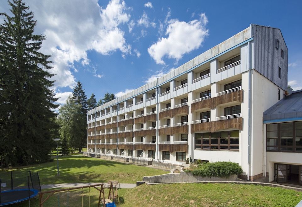 a large apartment building surrounded by trees and grass , with a playground in front of it at Home2 Suites by Hilton Atlanta Marietta