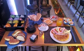 a table is set with various breakfast items , including toast , fruit , and a cup of tea at Lux Hotel