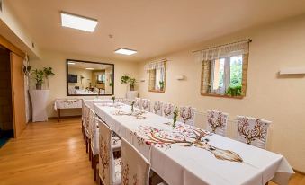 a long dining table with white tablecloths and chairs , set for a formal event or a banquet at Hotel Bella