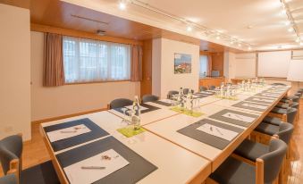 a conference room with a long table set for a meeting , surrounded by chairs and windows at Best Western Hotel Rebstock