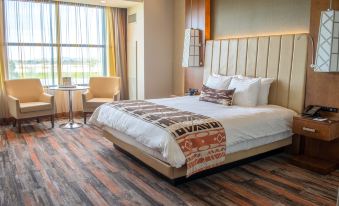 a large bed with white linens and a colorful blanket is in a hotel room at Soboba Casino Resort