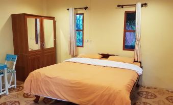 a cozy bedroom with two beds , one on the left and one on the right side of the room at Rainbow Resort