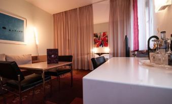a dining table with chairs and a lamp in a room with curtains and a television at Hotel-Restaurant Bären