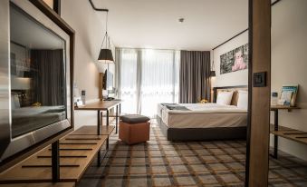 a modern hotel room with a large bed , desk , and window , decorated with checkered wallpaper at Rila Hotel Borovets