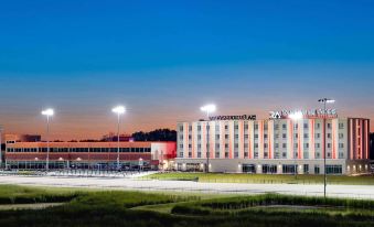 a large hotel building with multiple parking spaces and lights in front of it during sunset at Running Aces Hotel & Casino Trademark Collection by Wyndham