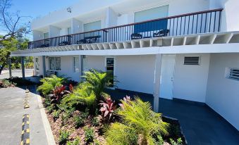 a modern white apartment building with balconies , surrounded by lush greenery and a clear blue sky at Marina de Salinas